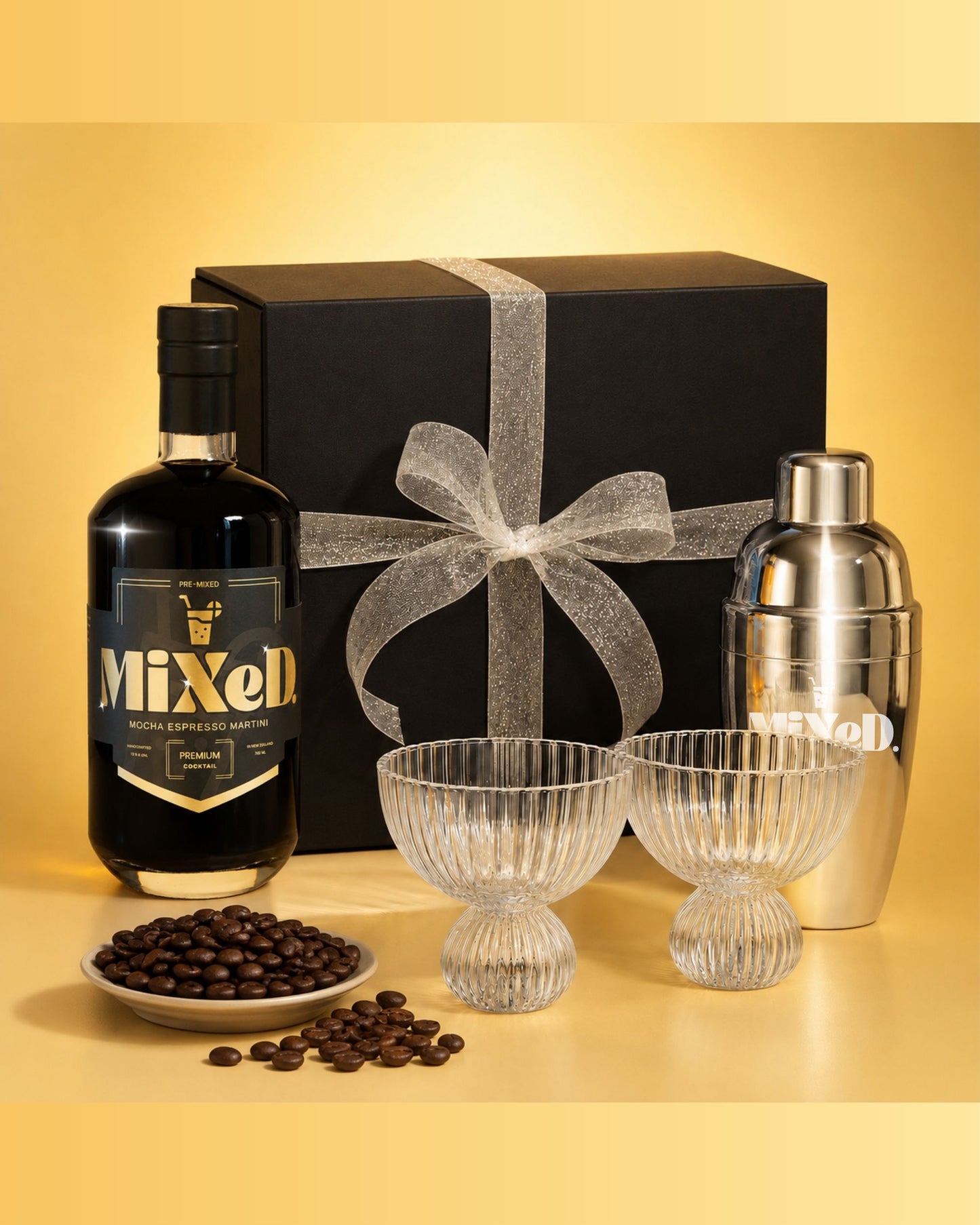 Bottle of Mixell liquor with a cocktail shaker, glasses, and coffee beans on a yellow background