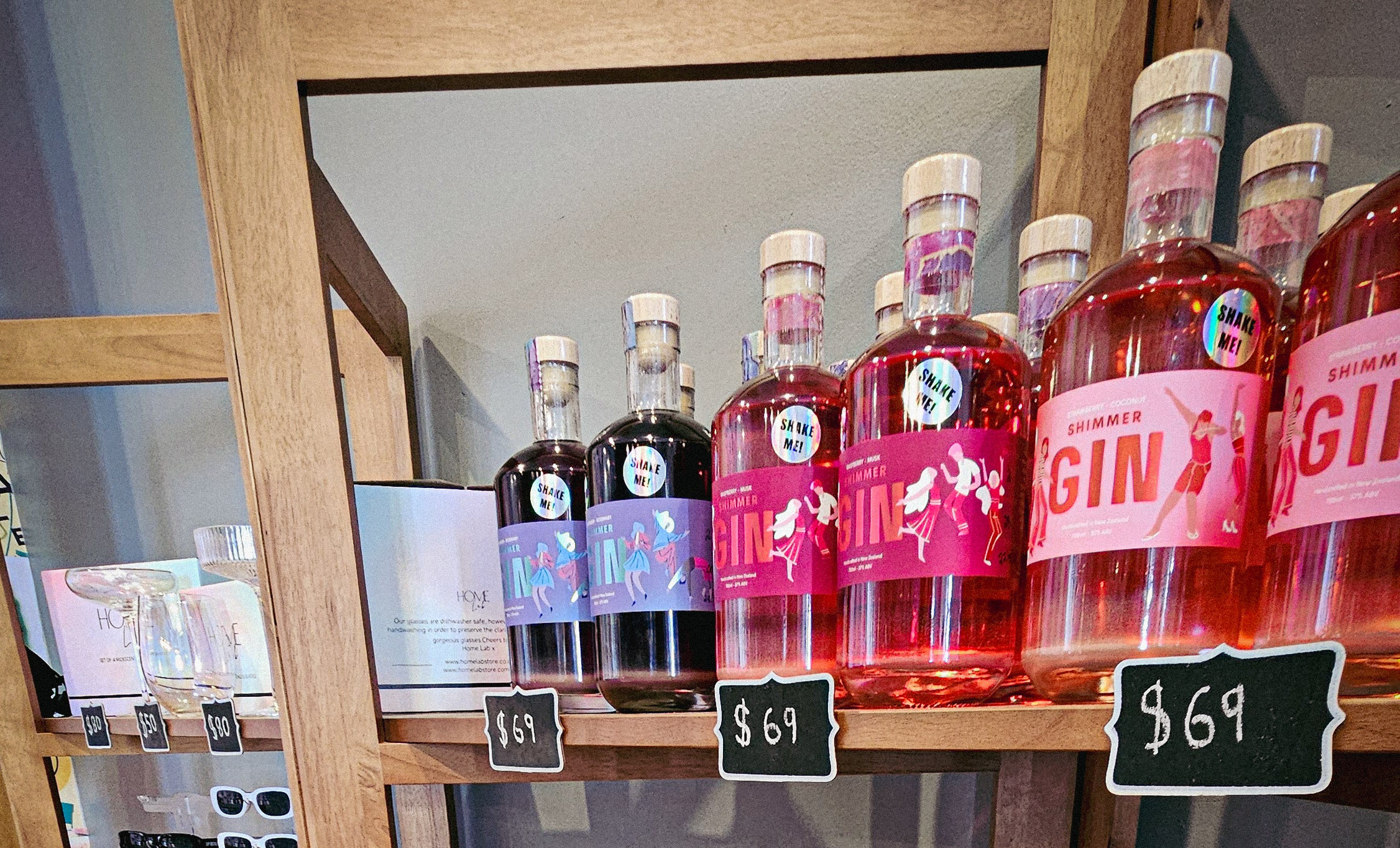 Bottles of gin on a shelf with price tags in a store setting.