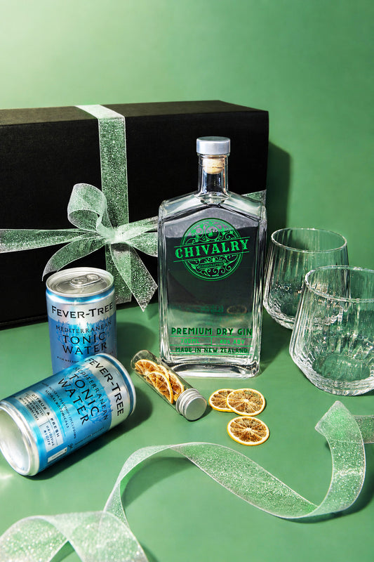 Fever-Tree gin bottle with tonic water cans and glasses on a green surface
