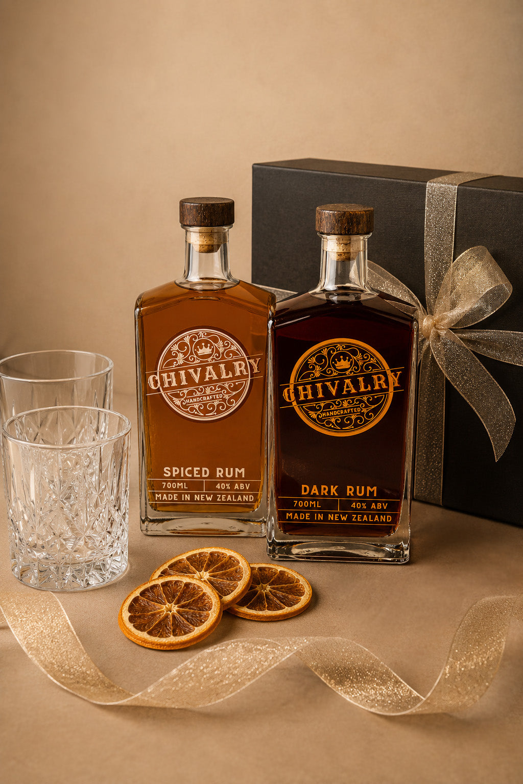 Two bottles of Chivalry rum with a gift box, glasses, and orange slices on a beige surface.