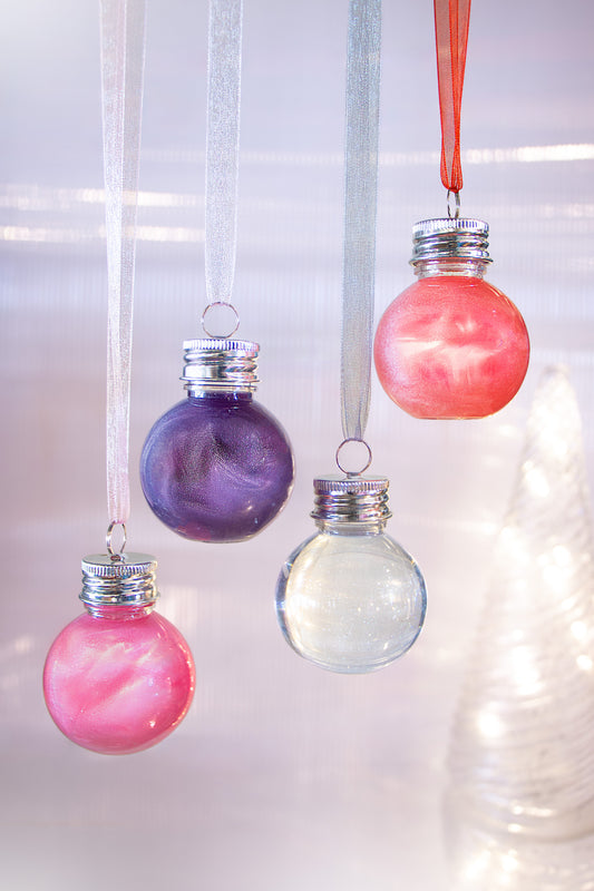 Marbled glass ornaments hanging against a blurred light background