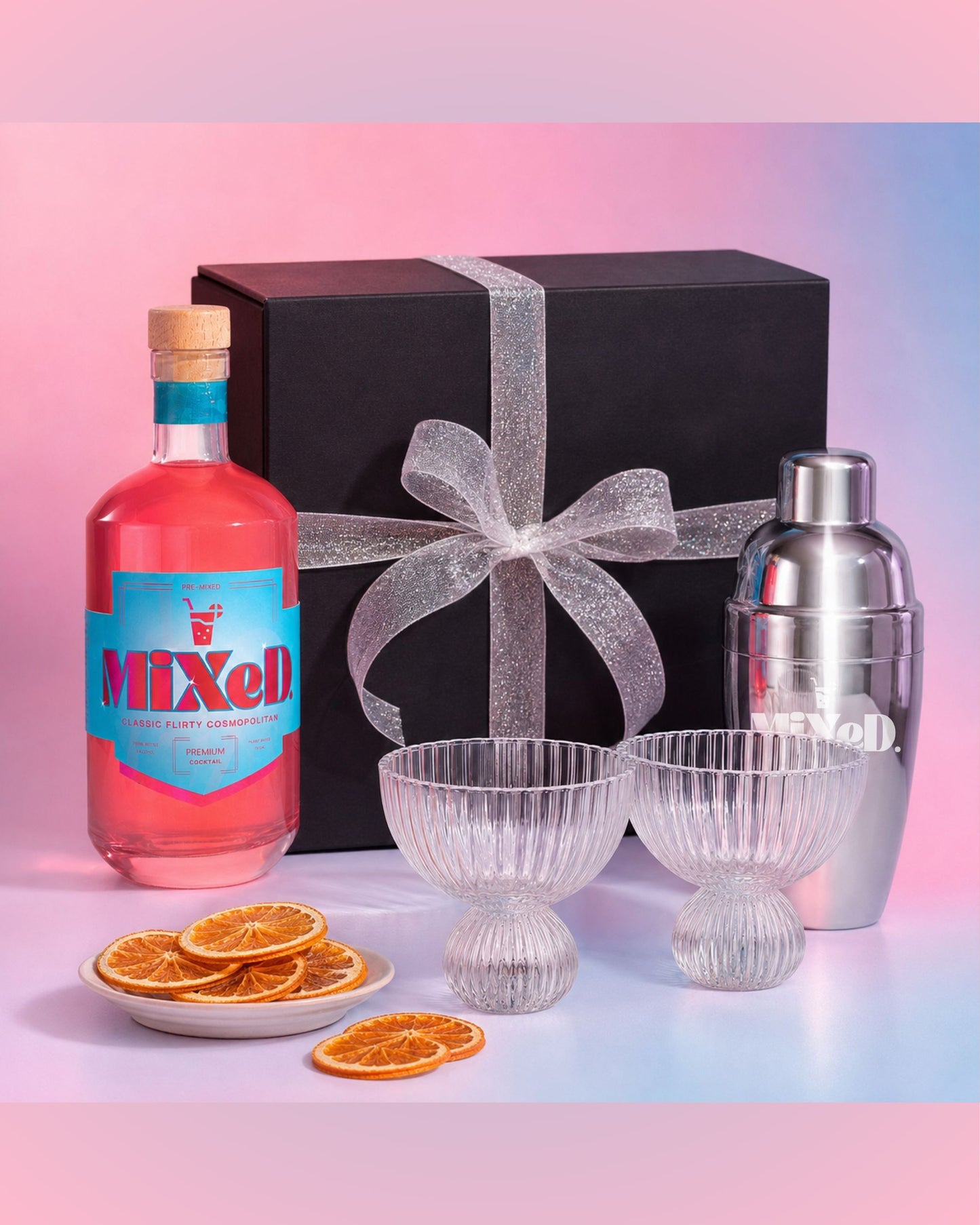 Bottle of Mixed berry liqueur with cocktail shaker, glasses, and orange slices on a gradient background