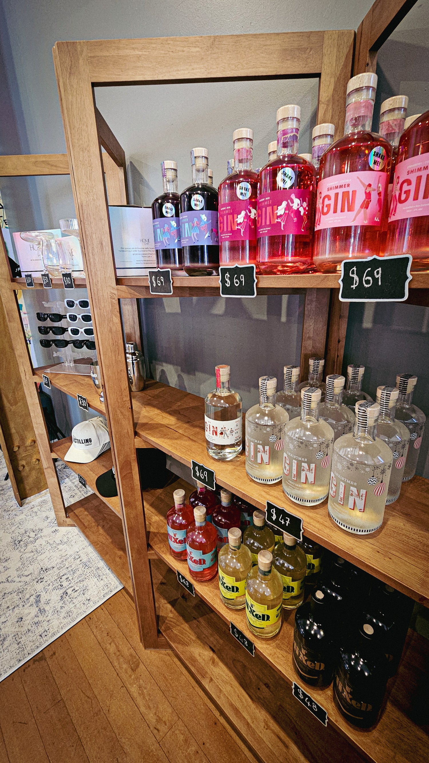 Shelves inside the SIP Distilling store displaying bottles of Shimmer Gin, MIXED cocktails, and other spirits and gifts.
