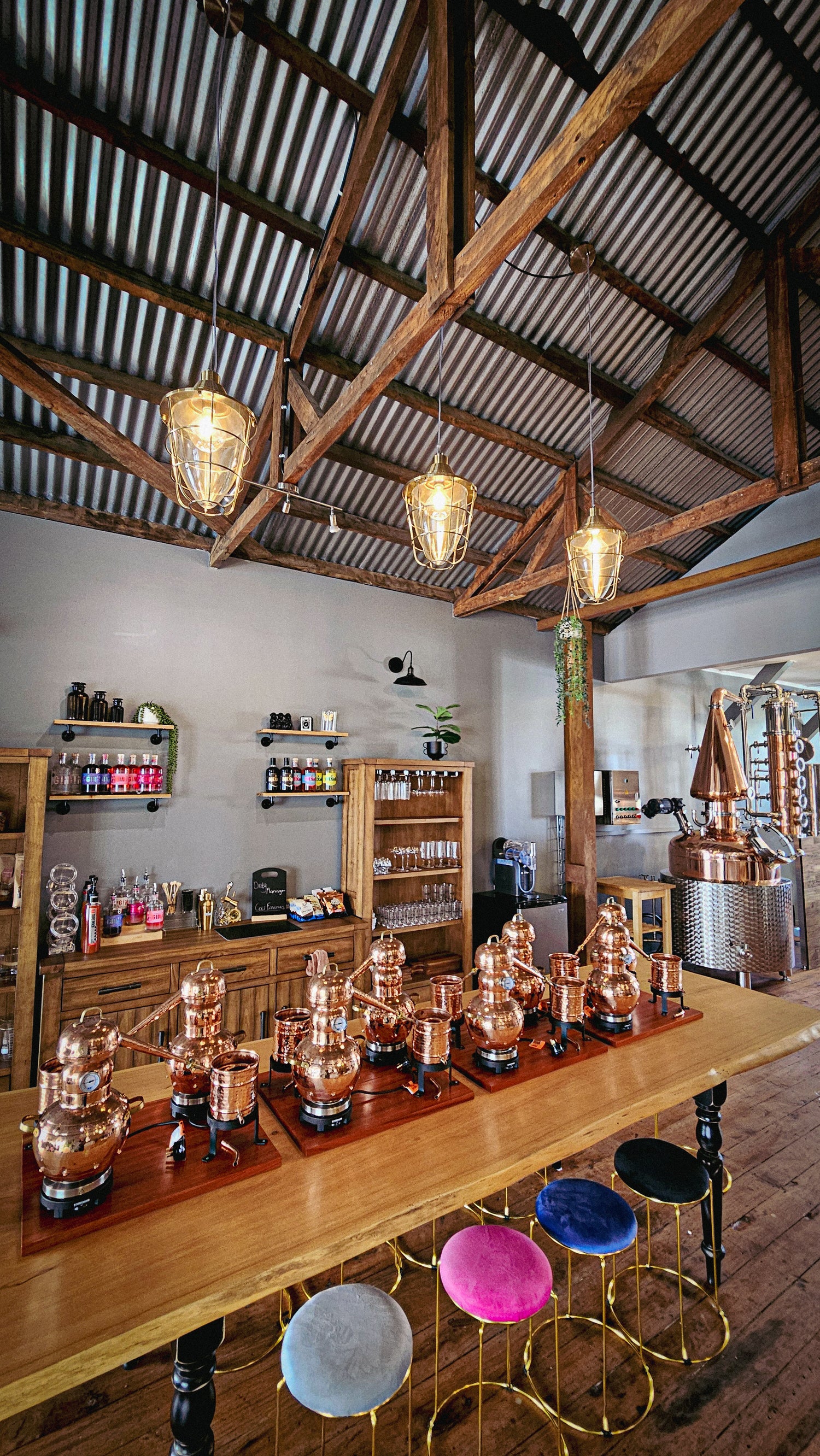 Bar area with wooden counter, stools, and a rustic ceiling.