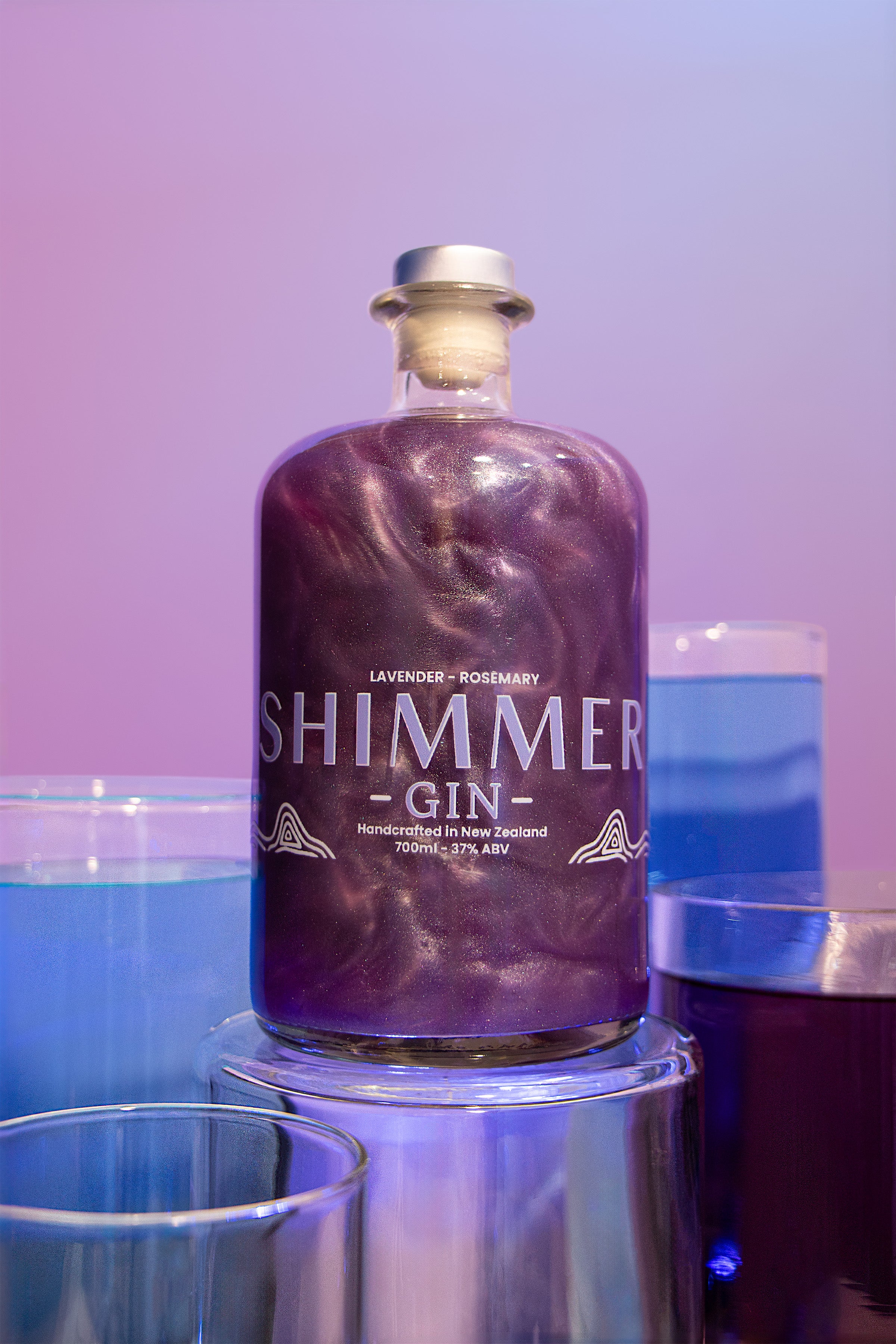 Bottle of Shimmer Gin with a purple marbled design on a blurred background