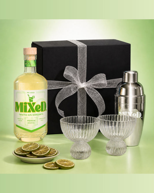 Cocktail set with Mixed Tonic Gin, cocktail shaker, and glasses on a green background