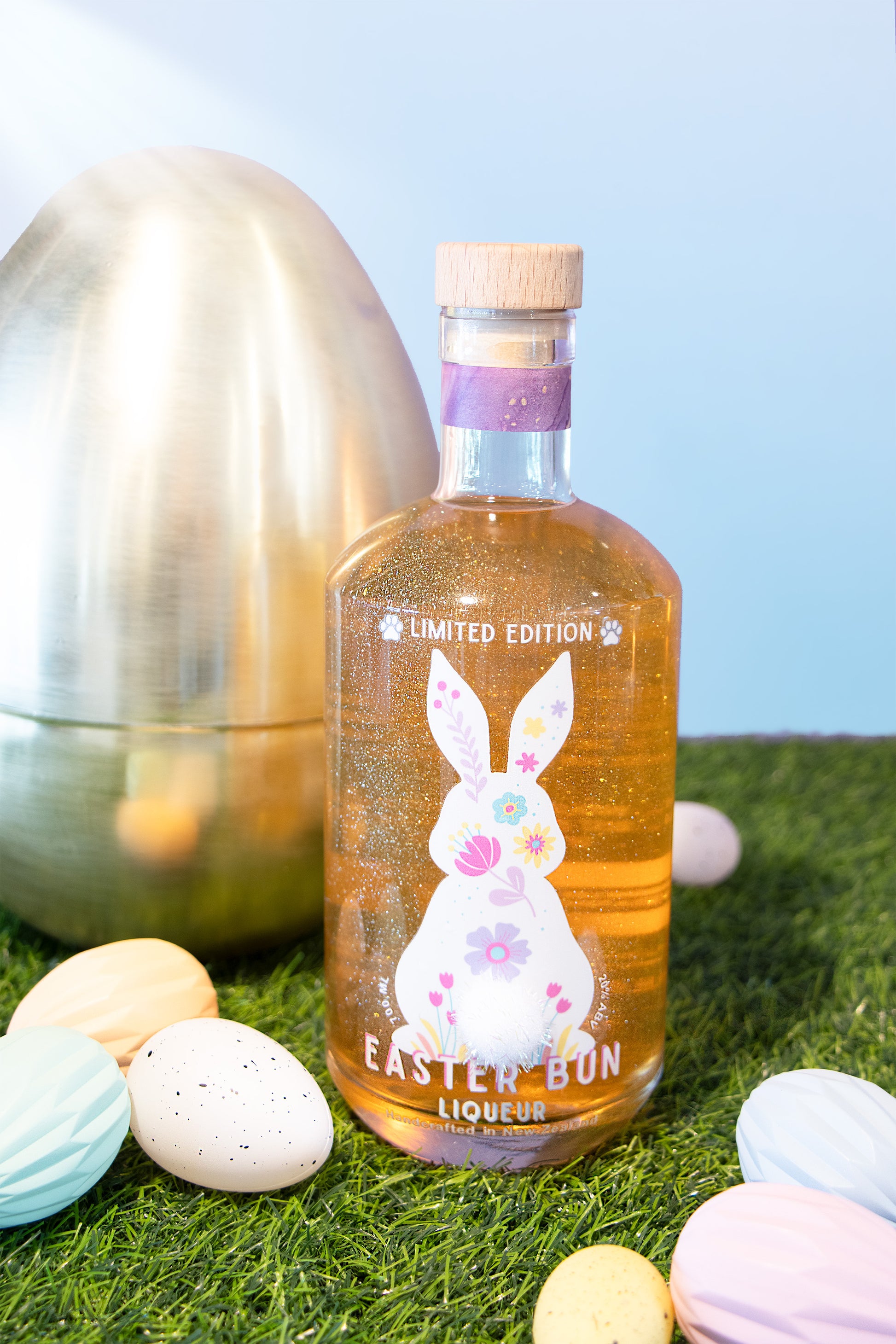 Bottle of Easter Bon Liqueur with decorative eggs on a grassy background